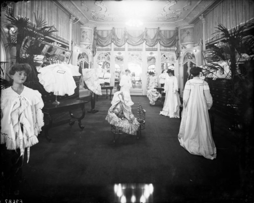 Interior view of the Daniels and Fisher store in Denver, Colorado; shows the "French Room," mannequins in lace and brocade gowns, mirrors and a plaster ceiling.