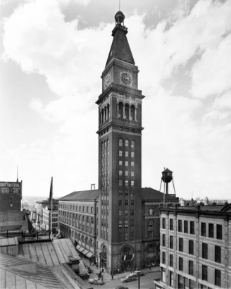 View of the Daniels and Fisher Stores building and tower, in Denver, Colorado; also shows 16th (Sixteenth) Street, a water tower, and automobile traffic.