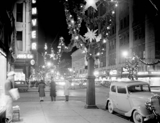 Nighttime view of 16th (Sixteenth) Street in downtown Denver, Colorado. Streetlights are decorated with greenery and Christmas lights.