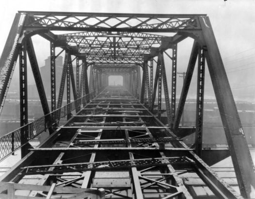 View of the partially constructed 23rd (Twenty-third) Street Viaduct over rail yards in the Five Points neighborhood of Denver, Colorado. Workmen are on the bridge in the distance.