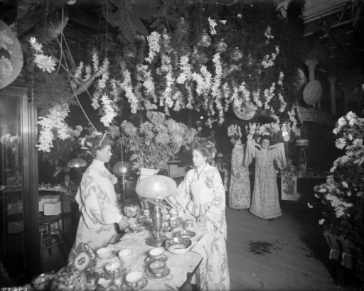 Interior view of the Daniels and Fisher store in Denver, Colorado; shows women in kimonos, chrysanthemums, and China tea service.