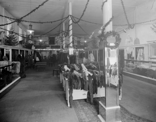 Interior view of the Daniels and Fisher store in Denver, Colorado; shows racks of fur shawls, Christmas trees, and taxidermied animals.
