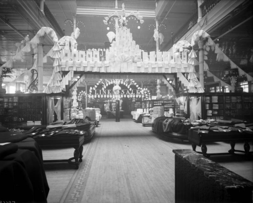 Interior view of the Daniels and Fisher store in Denver, Colorado; shows displays of fabric and clothing. Sign reads: "Linen Sale."