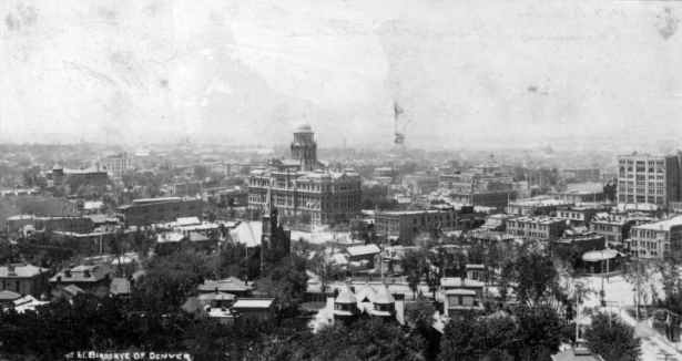 Rooftop view of downtown Denver, Colorado. Buildings include the Arapahoe County Courthouse. Signs read: "The Shannon Reid Plumbing and Heating Co" and "Uhland's Drug Store."