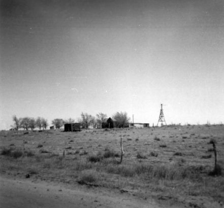 View of the terrain that surrounds the area in which the Sand Creek Massacre took place, November 29 and 30, 1864, in Kiowa County, Colorado; United States troops killed some 200 Native Americans (Cheyenne and Arapaho), two thirds of whom were women and children. A farm house, windmill, and utility buildings stand on an open prairie landscape.