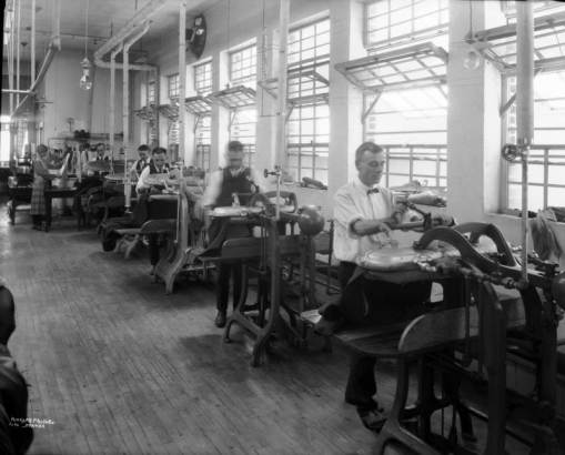 Interior view of a laundry, in Denver, Colorado; shows men and a woman working with steam presses.