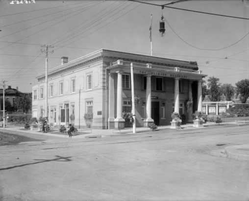 View of "The Olinger Mortuary" at 16th (Sixteenth) and Boulder Streets in the Highland neighborhood of Denver, Colorado; shows a brick building with urns, columns, and a balustrade.