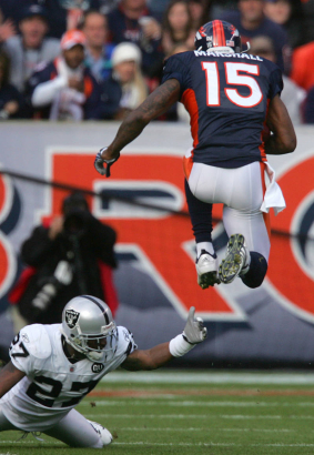 (683) Brandon Marshall jumps over Rashad Baker in the first quarter of the Denver Broncos against the Oakland Raiders at Invesco Field at Mile High in Denver, Colo., on Sunday, Nov. 23, 2008. (CHRIS SCHNEIDER/ROCKY MOUNTAIN NEWS) **