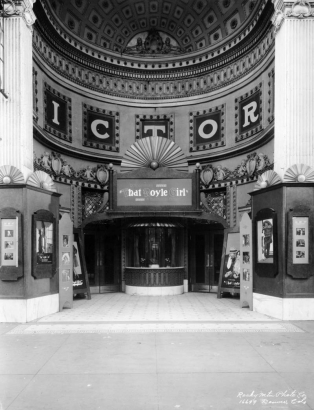 View of the Victory Theater in Denver, Colorado; shows the arched entry, ornate plaster, and signs: "D. W. Griffith's That Boyle Girl, A Paramount Picture."