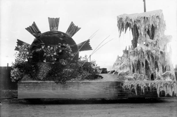 View of a parade float, built for the festival of Mountain and Plain, in Denver, Colorado. The float depicts a waterwheel and a large group of icicles.