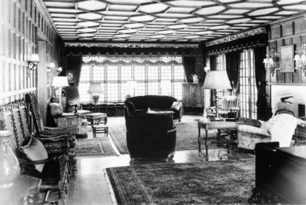 Interior view of the John Albert Ferguson house at 700 Washington Street in the Capitol Hill neighborhood of Denver, Colorado. Elizabethan style decor includes chairs, sofas, tables, lamps, heavy drapes, and ornate trim.