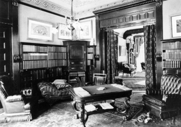 Interior view of the Mitchell Benedict residence (Lang & Pugh architects) in Denver, Colorado; decor includes tuck and roll upholstery, book cases, coved ceilings, and wood door frames.