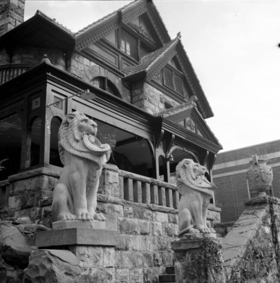 View of the J. J. and Margaret Tobin (Molly) Brown house at 1340 Pennsylvania Street in the Capitol Hill neighborhood of Denver, Colorado. The Queen Anne-style house has a tile roof, circular balcony, covered porch and rusticated stone wall with terra-cotta statuary.