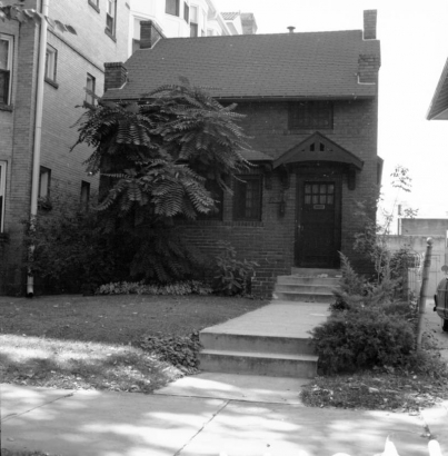 View of the George E. Burr residence at 1325 Logan Street in the Capitol Hill neighborhood of Denver, Colorado. The two-story brick house has a pitched roof and covered entryway.