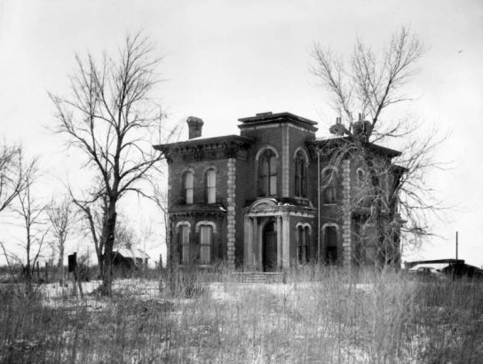 View of the John B. Hindry home on North Washington Street in Denver, Colorado; shows a house with quoins, bay window, portico, and a cornice.
