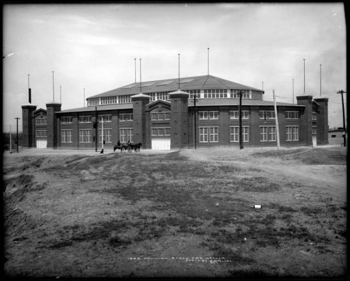 Exterior view of Pavilion (also called National Amphitheater or "Old Stadium") on 46th Avenue built by Denver Union Stock Yard Company at cost of over $200,000, Denver, Colorado;  construction began in May, 1908 and was completed by January, 1909 in time for National Western Stock Show; dog, horse-drawn carriage & horseback rider in front of pavilion or stadium.