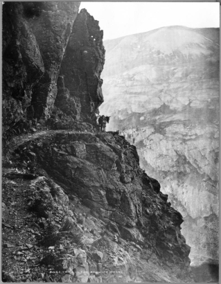 View of narrow mountain path with horse or mule rounding bend, somewhere in the San Juan Mountains, possibly near Silverton, Colorado; rocky path along narrow precipice, Rocky Mountains; photograph attributed to McClure, original by William H. Jackson.