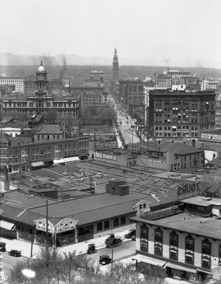 Rooftop view of downtown Denver, Colorado. Buildings include the Arapahoe County Courthouse, Orpheum Theater, Daniels and Fisher Tower, Kittredge Building, and the Majestic Building. Signs read: "The Stanley Motor Carriage Co.," "Orpheum Modern Vaudeville," "Kelly Springfield Tires," "Boss Rubber Co.," "Plymouth Hotel," and "Auto Equipment Co."