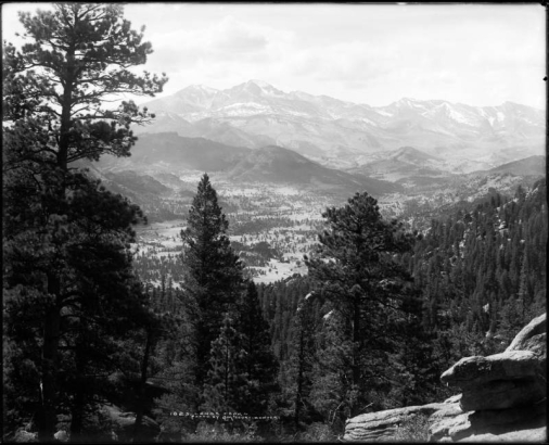 Distant view of Longs Peak (elevation 14,255 feet) and Mount Meeker (elevation 13,911 feet) from road above Estes Park, Colorado; backside of Stanley Hotel and distant view of Estes Park, center left; Rocky Mountains, Rocky Mountain National Park.