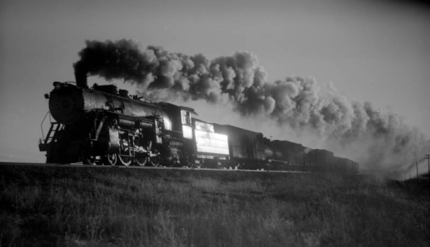 Freight, eastbound; 15 cars, 50 MPH, good smoke, with brilliant sunlight reflecting off the tender. Photographed: east of Hudson, Colo., February 15, 1937.