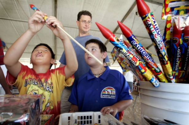 Hunter Tompkins (cq) ,8 (left) his brother Hudson Tompkins,7, and their dad Mark Tompkins (cq) from Centennial,CO check out the fireworks at Olde Glory Fireworks stand at Arapahoe and Parker in unincorporated Arapahoe County Wednesday June 29,2005. Hun...