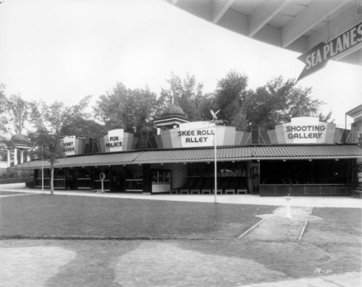 View of concession stands at Lakeside Amusement Park in Lakeside (Jefferson County), Colorado. Signs read: "Penny Arcade," "Fun Palace," "Skee Roll Alley," "Shooting Gallery," and "Sea Planes."