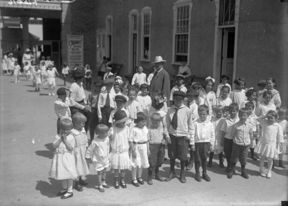 Children pose at Lakeside Amusement Park in Lakeside (Jefferson County), Colorado; adults are in the background.