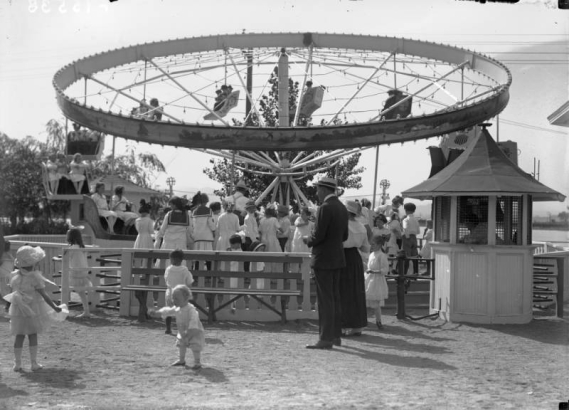 Children ride an attraction at White City Amusement Park (later called Lakeside) in Lakeside (Jefferson County), Colorado; toddlers play in the foreground.