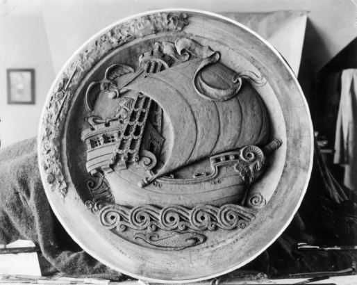 View of a clay medallion sculpted by Robert Garrison for the Park Hill Branch of the Denver Public Library in Denver, Colorado; depicts a ship, an eagle, waves, and a fish.