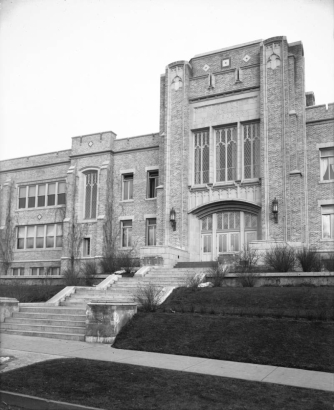 View of the Byers Junior High School entry and steps in the Speer neighborhood of Denver, Colorado; features leaded glass, tracery, and brick with stone and ceramic tile trim.
