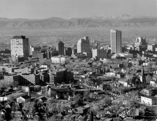Aerial view of the skyline of the central business district of Denver, Colorado. Shows First National Bank Building, Continental Oil Company Building, Brown Palace Hotel, Mile High Center, Denver Club Building, Rocky Mountain Telephone Building, Denver Gas and Electric Building, Republic Building, and Scottish Rite Masonic Temple. The foothills of the Front Range are in the distance.