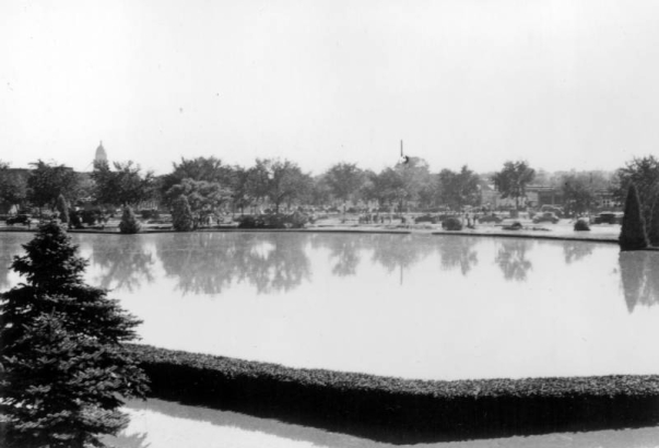 View of a Cherry Creek flood in Denver, Colorado after the Castlewood Canyon Dam break; shows an expanse of water and landscaping at the Sunken Gardens.
