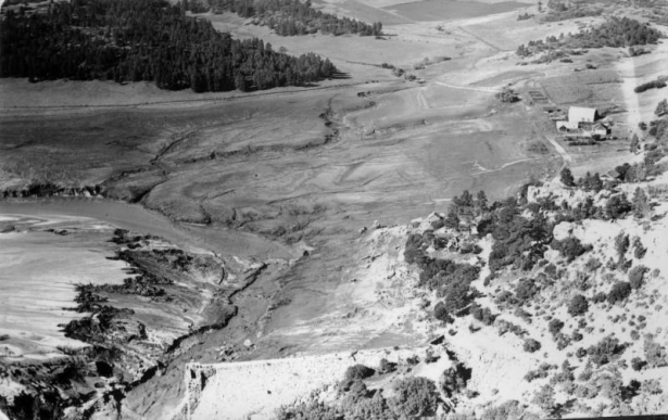 Aerial view of Cherry Creek and the destroyed Castlewood Dam in Douglas County, Colorado after the flood. Shows a farm house and barn.
