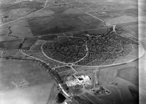 Aerial view of Fairmount Cemetery and the Windsor neighborhood of Denver, Colorado; the crematorium, offices and Highline Canal are in the foreground. Quebec Street, Byers Avenue, Road 13, and Cherry Creek are in the background.
