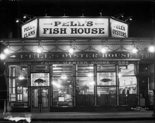 Nighttime view of Pell's Oyster House restaurant at 520 16th (Sixteenth) Street in downtown Denver, Colorado; features leaded glass, gilt letters, garlands, and signs: "Pell's Clams, Pell's Fish House, Pell's Oyster House."