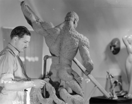 A man works with a clay nude sculpture of a male probably in Colorado.