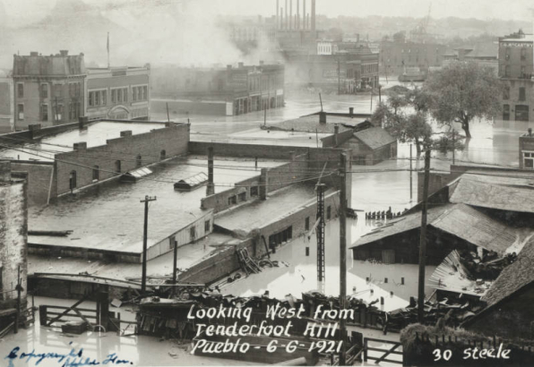View of flooded buildings, debris and flood water from the Arkansas River in Pueblo (Pueblo County), Colorado. Shows submerged commercial buildings, houses and telephone poles in Goat Hill (Tenderfoot Hill) in northeast Pueblo.