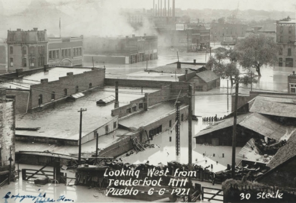 View of flooded buildings, debris and flood water from the Arkansas River in Pueblo (Pueblo County), Colorado. Shows submerged commercial buildings, houses and telephone poles in Goat Hill (Tenderfoot Hill) in northeast Pueblo.