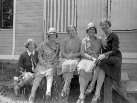 Five women, probably members of H. H. Lake's family, sit on steps  in front of a house, probably in Central City, Colorado, where Lake worked  at the First National Bank for 47 years.