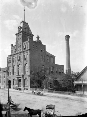 The Milwaukee Brewery Company was established in 1859 by James Endlich at 10th and Larimer Streets in Denver, Colorado. In 1860, the brewery was sold to John Good, who enlarged it and renamed it after the Tivoli Gardens in Copenhagen. In 1901, the brewery merged with the Union Brewing Company to form the Tivoli-Union Brewery. The plant shown here continued to operate until 1969, producing Denver Beer. Several horse-drawn  wagons are on the dirt street in front of the building.