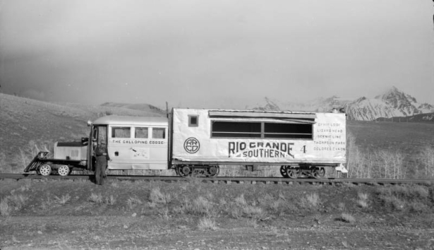 Left side view of motor car, close view; Galloping Goose, with C.A. Rhodes in doorway. Photographed: Peak, Colorado, May 23, 1951.