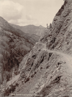 View of the Ouray - Silverton road, the Otto Mears toll road, in Ouray County, Colorado; log retaining structures bridge sections of the road. The Uncompahgre River is in the valley below.