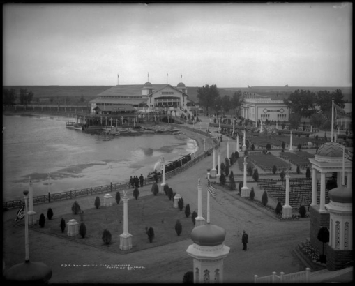 Bird's eye view of the "White City" (later called Lakeside Amusement Park), Lakeside, Colorado near Denver; Lake Rhoda, numerous rows of benches (bandstand not in view), rink, boat house, ball room and miniature train ride.