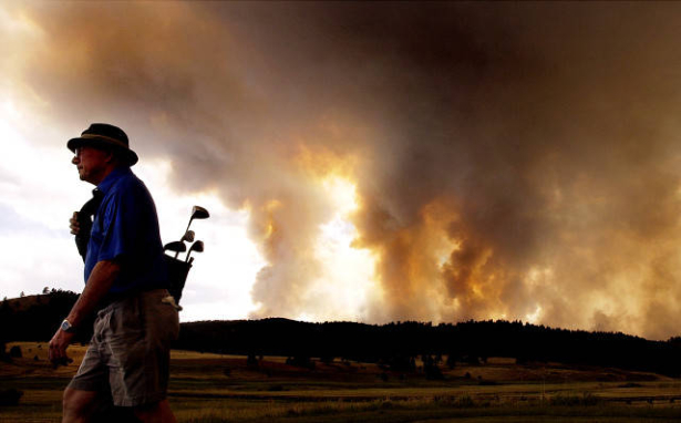Eugene Brumley tries to get in a round of golf as the Hayman Fire rages.