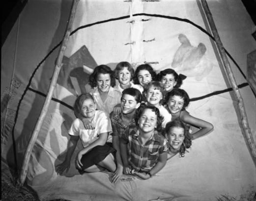 Camp Fire Girls smile and pose in a tipi in Denver, Colorado.