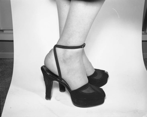 View of a woman model's feet in a pair of  high heeled, open toed sandals with cork soles, advertising copy for Neusteters department stores in Colorado.