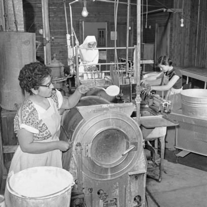 Interior view at the Leadville Hospital in Leadville (Lake County), Colorado; women work in the laundry. Shows a washing machine, a mangle and a steam press.