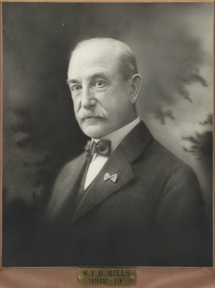 Studio portrait of W.F.R. Mills, Mayor of Denver, Colorado, from 1918 to 1919.  Mayor Mills is balding he has a mustache, and  wears a jacket and bow tie. He has a pin on his lapel.