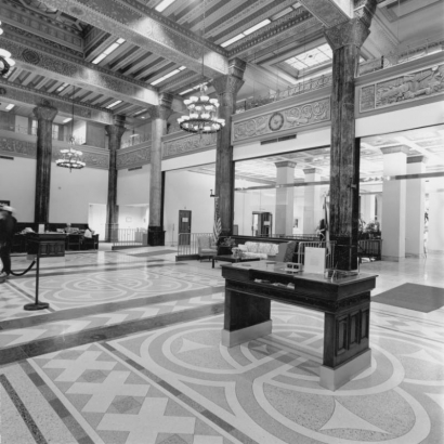 Interior view of the Women's Bank of Denver building at 821 17th (Seventeenth) Street in Denver, Colorado; shows skylights, ornate friezes, stencils, columns, chandeliers, and mastic floors with geometric patterns.