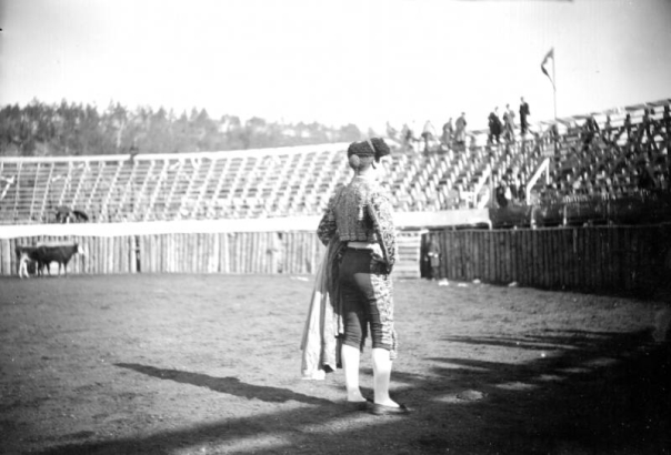 A matador, possibly Jose Marrero, looks into the stands during the bullfight on August 24 or 25, 1895, in the wood bullring built at the race track in Gillett, Colorado, for the occasion. The grandstand is almost empty, with people standing in the top row. Joe Wolfe was the organizer of the event which caused a scandal because of its cruelty to animals.